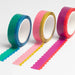 Three rolls of colorful tape with scalloped edges on a white background