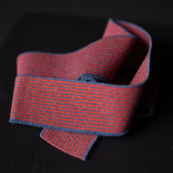 Red and blue striped ribbon on a dark surface