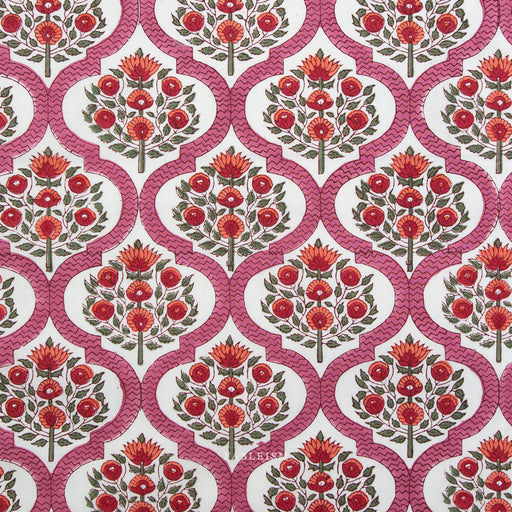 Patterned fabric with red floral design on a pink background