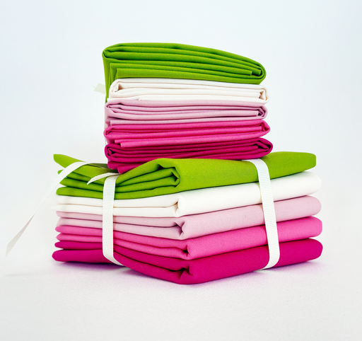 Stack of folded fabric in green, pink, and white on a white background