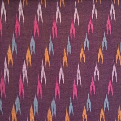 A close-up of a woven fabric with a dark purple base and a repeating diagonal ikat pattern in pink, orange, and light blue.