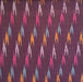 A close-up of a woven fabric with a dark purple base and a repeating diagonal ikat pattern in pink, orange, and light blue.